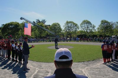 Opening Day
Rick Plunkett throws out the first pitch in memory of his son Ryan Plunkett, for whom the Old Rochester Youth Baseball League has commemorated a new award going to the league’s best pitcher. Rick Plunkett is also pictured with Rochester Police Officer Austin Alves, who was Ryan Plunkett’s catcher when the two played together on the A’s of the ORYB Major League. Alves recalled a home run Ryan Plunkett hit over the left-field wall that got caught up in the top of the batting cage at Gifford Park. 
