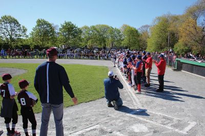 Opening Day
Rick Plunkett throws out the first pitch in memory of his son Ryan Plunkett, for whom the Old Rochester Youth Baseball League has commemorated a new award going to the league’s best pitcher. Rick Plunkett is also pictured with Rochester Police Officer Austin Alves, who was Ryan Plunkett’s catcher when the two played together on the A’s of the ORYB Major League. Alves recalled a home run Ryan Plunkett hit over the left-field wall that got caught up in the top of the batting cage at Gifford Park. 
