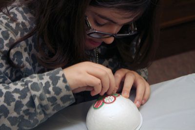 Holiday Ornaments
Lexie Tavares of Mattapoisett creates an ornament made of foam, covered in paper circles affixed by straight pins.  Photo by Eric Tripoli.
