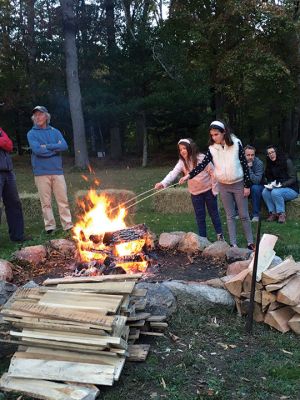 Salty's Silvery Moon Soiree
On the evening of October 23, the Mattapoisett Land Trust hosted its annual Salty’s Silvery Moon Soiree at Dunseith Gardens. The yearly autumn event finds families gathering around a roaring fire pit and toasting marshmallows or creating delicious desserts while listening to live music. On this night, music was provided by Jeff Dunn, and storyteller Danny Dullea entertained all with marvelous tales about the natural world. Photos by Marilou Newell
