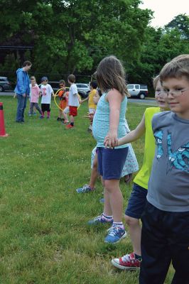 Field Day Fun at Sippican School 
Friday morning we caught some first-graders in the middle of a hula-hoop relay on the grounds of Sippican School. Holding hands and cheering each other on, the kids twisted and turned themselves through the hoops and the first team to get their hoop to travel down and up the line again won the relay. Can you guess which team won? Photo by Jean Perry
