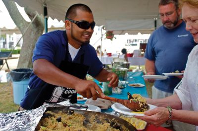 Summer Sizzler 
Ixe Velazquez (left) serves his family recipe seafood paella to the patrons of this year's Summer Sizzler Men Who Cook event, organized by the Women's Center of New Bedford, on Sunday, July 15, 2012. Photo by Eric Tripoli
