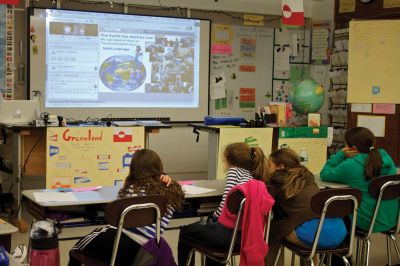 World Science
Old Hammondtown School fourth grade teacher Kevin Tavares (left) monitors a webinar that he and his students participated in on Monday, April 23, 2012.  They, along with people checking in from around the US and Canada, listened to two scientists in Greenland explain the work they do studying the Earth’s cryosphere. Tavares has been including interactive use of technology as a regular part of his students’ education. Photo By Eric Tripoli.
