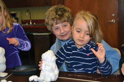 Build-your-own Snowman
Under the direction of Jeanne McCullough, children at the Mattapoisett Free Library on December 30 participated in a step-by-step build-your-own snowperson activity during the winter school break. Little fingers sticky with glue flattened out cotton balls and fastened them to prefabricated Styrofoam snowperson shapes, and then glued on the trimmings under the guidance of caregivers. Photos by Jean Perry
