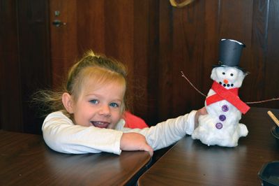 Build-your-own Snowman
Under the direction of Jeanne McCullough, children at the Mattapoisett Free Library on December 30 participated in a step-by-step build-your-own snowperson activity during the winter school break. Little fingers sticky with glue flattened out cotton balls and fastened them to prefabricated Styrofoam snowperson shapes, and then glued on the trimmings under the guidance of caregivers. Photos by Jean Perry
