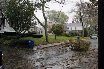 Storm Damage
An uprooted tree lays across the front lawn of a ranch house on Front Street near Silvershell Beach in Marion last Friday. Earlier in the day, a Mattapoisett Fire truck monitored the scene after a downed powerline caused a fire and closed Water Street down the street from Town Hall. North of Route 195 in Mattapoisett, a snapped-off tree is held up by a utility wire. Photos by Mick Colageo and Marilou Newell
