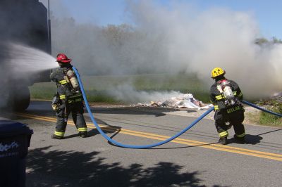 Trash Fire
A trash truck was up in smoke on Long Plain Road in Mattapoisett last week. Before I knew it, engines and firemen appeared in full gear. The Fire Department had the driver dump all the trash in a field near the road where the fire could be more safely extinguished. Photo by Ellie Higgins
