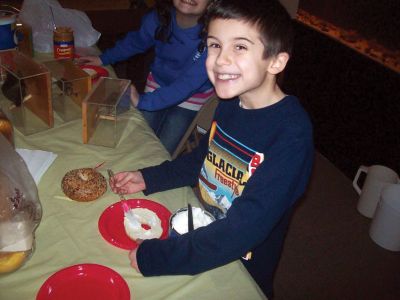 Bagel Birdfeeders
Mark Sylvia helped make bagel birdfeeders during the Marion Natural History Museum backyard bird afterschool program. Pictured here, Luke Couto spread some shortening on his bagel birdfeeder during the program. Photo courtesy of Elizabeth Leidhold.
