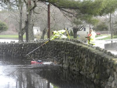 A Lot of Water
Britt Stock and Joan Whitley of the Coast Guard use doppler radar to manually measure the flow of water in the Mattapoisett River after flood waters nocked out the monitoring equipment. Photo by Paul Lopes
