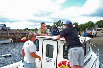 Preparing to Patrol
Mattapoisett Harbormaster Steve Mach (center) and Assistant Harbormasters Milt Heuberger and Kenneth Pacheco put the finishing touches  and redesigned vinyl lettering  on the newly-purchased SeaHawk Harbormaster's vessel at the Town Wharf. (Photo by Kenneth J. Souza).
