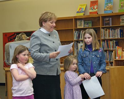 Sippican Student-Author
A budding young author was recognized during a recent School Committee Meeting at Sippican School. Maura Lonergan, a third grade student in Paula McKeens class, won a statewide essay contest on Bullying. (L. to R.) Elizabeth Lonergan (sister); Dona Mahoney, Principal of Sippican School; Fiona Lonergan (sister); and award recipient Maura Lonergan listen while Ms. Mahoney reads a proclamation from the Marion School Committee.
