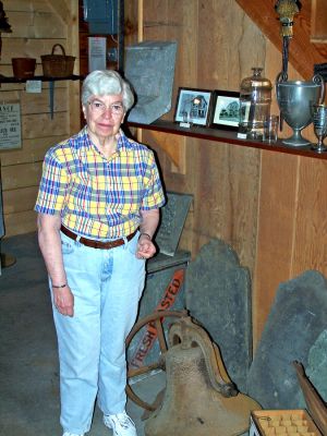 Stories in Stone
Mattapoisett Historical Museum Curator Bette Roberts poses in front of a few of the historic gravestones on display at the Mattapoisett museum. Ms. Roberts recently gave a guided tour and talk on the Barlow Burying Ground in Mattapoisett. (Photo by Nancy MacKenzie).
