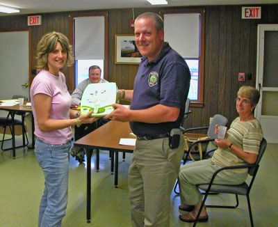 Defib Donation
Rochester Chief Dispatcher Tracy Eldridge (left) presents Rochester Police Chief Paul Magee (right) with a new portable defibrillator which Ms. Eldridge managed to purchase with a donation she solicited from People in Business Care (PIBC). The $3,000 donated unit will be kept inside one of the on-duty police cruisers at all times. (Photo by Kenneth J. Souza).
