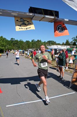 Marion Village 5K
Nick Grey of Marion crosses the finish line in the tenth annual Marion Village 5K Road Race, completing the course in 21:11 and finishing 44th overall. (Photo by Robert Chiarito).
