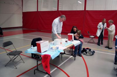 Flu Clinic
Dr. Tom Streeter prepares to vaccinate a little girl during the recent Marion Flu Clinic held at Tabor Academy on November 8 while Town Nurse Amanda Stone, RN, and Board of Health member Betsy Dunn confer in the background. (Photo by Robert Chiarito).
