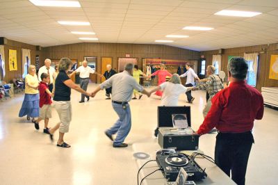 Do-Si-Do in Marion
On Sunday, September 14, the first of what is hoped to be an annual series of Marion Square Dances was held inside the Marion Community Center. Although initially slated to take place in the parking lot adjacent to the Marion General Store, the weekends rainy weather forced the event indoors. Caller Jim Schell of Lakeville had veteran square dancers and novices alike promenading, allemanding, bowing to their partners and do-si-doing with ease. (Photo by Robert Chiarito).
