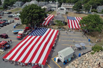 Glory Unfurled
Mattapoisett's weeklong 150th Sesquicentennial Celebration was capped off with a closing ceremony featuring the glorious unfurling of three large versions of the Stars and Stripes, courtesy of the National Flag Truck exhibit, in the area of the Town Wharf and Shipyard Park on Sunday afternoon, August 12. (Photo by Tim Smith).
