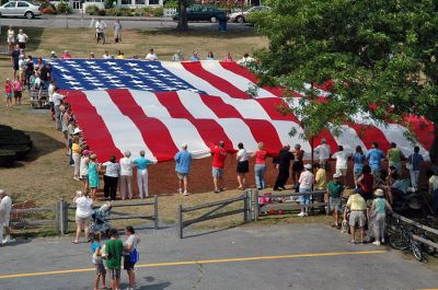 Glory Unfurled
Mattapoisett's weeklong 150th Sesquicentennial Celebration was capped off with a closing ceremony featuring the glorious unfurling of three large versions of the Stars and Stripes, courtesy of the National Flag Truck exhibit, in the area of the Town Wharf and Shipyard Park on Sunday afternoon, August 12. (Photo by Tim Smith).
