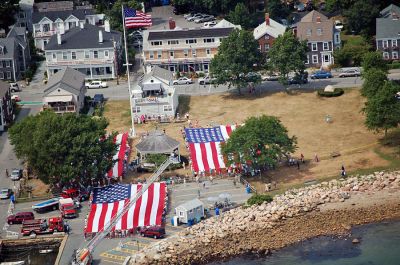 Glory Unfurled
Mattapoisett's weeklong 150th Sesquicentennial Celebration was capped off with a closing ceremony featuring the glorious unfurling of three large versions of the Stars and Stripes, courtesy of the National Flag Truck exhibit, in the area of the Town Wharf and Shipyard Park on Sunday afternoon, August 12. (Photo by Ken Howland).
