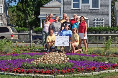 Garden Group Glory
Members of Mattapoisetts 150th Garden Group recently posed for this aerial shot of the sesquicentennial logo they recreated out of plantings at Shipyard Park. The group members have put in countless hours planting this and other beds from Shipyard Park to Neds Point to commemorate the towns 150th birthday. This photo is also being planned as the cover for the next Annual Town Report. (Photo by Robert Chiarito).
