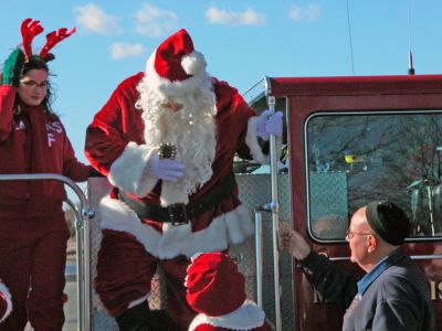 Here Comes Santa Claus
Santa arrives in Shipyard Park during Mattapoisett's first annual Holiday Village Stroll on Saturday, December 2. Santa also brought along Mrs. Claus, his helpful elves, Rudolph the Red-Nosed Reindeer, and Frosty the Snowman to delight children during the festivities. (Photo by Robert Chiarito).
