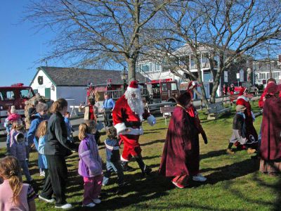 Here Comes Santa Claus
Santa arrives in Shipyard Park during Mattapoisett's first annual Holiday Village Stroll on Saturday, December 2. Santa also brought along Mrs. Claus, his helpful elves, Rudolph the Red-Nosed Reindeer, and Frosty the Snowman to delight children during the festivities. (Photo by Robert Chiarito).
