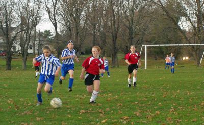 Kicking and Screaming
Dartmouths Julia Silverstein controls the ball in the midfield against tight defensive pressure during last Sundays (November 13) U11 Girls Mariner Soccer League game against the Metro Black Magic SC out of Franklin. Warehams Madison Catarius trails Silverstein from her fullback position to lend support to the Mariner attack. Mariner ended up losing the match, 2-0. (Photo by and courtesy of Luis Couto).
