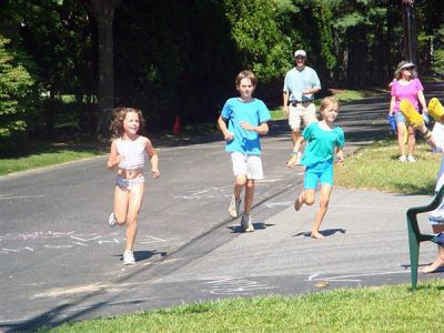 Piney Point Winners
Lucy Saltonstall of Marion prepares to cross the finish line in the 2008 Piney Point Beach Club (PPBC) Youth Triathlon, with the support of her brother Willie and friend LuLu Russell running alongside her. The annual event was held on Saturday, August 23 in Marion. (Photo courtesy of Ron Bilodeau).

