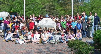 Firefighters' Memorial
Second graders at Rochesters Memorial School took their annual walking field trip to the Firefighters Memorial to plant red geraniums. For the past six years, the young gardeners have planted before Memorial Day to give back to the community that has given so much to them. Armed with a variety of digging tools, watering cans, and a host of parent volunteers, these children enjoyed the work and appreciated the support of the Highway Department, Fire Department and Police Department. (Photo by Connie Holt).
