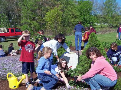 Firefighters' Memorial
Second graders at Rochesters Memorial School took their annual walking field trip to the Firefighters Memorial to plant red geraniums. For the past six years, the young gardeners have planted before Memorial Day to give back to the community that has given so much to them. Armed with a variety of digging tools, watering cans, and a host of parent volunteers, these children enjoyed the work and appreciated the support of the Highway Department, Fire Department and Police Department. (Photo by Connie Holt).
