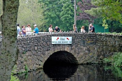 Water Works
Little did Elise Goyette of Rochester know that her partner in boat #43, M.J. Linane, was planning to finish their adventure on the Mattapoisett River with a marriage proposal after crossing the finish line. This sign was posted as the duo made their final trek toward the Herring Weir. (Photo by Tim Smith).
