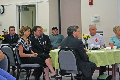 Dispatcher Honored
Rochester Chief Dispatcher Tracy Eldridge (seated next to husband, Highway Surveyor Jeff Eldridge) listens to Police Chief Paul Magee read his nomination letter for the Thirteenth Annual Jeff Grossman 9-1-1 Telecommunicator of the Year Award which Ms. Eldridge received on June 29. (Photo by Robert Chiarito).
