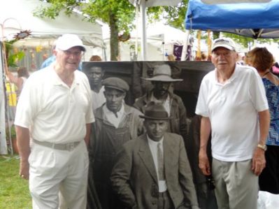 Wanderer Descendants
Brothers Bob Furtado, left, and Carl Furtado, right, pose in front of a picture of their ancestor, Captain Antone Edwards, who was the last captain of the [i]Wanderer[/i]. The Furtados assisted at the Descendants of Whaling Masters booth at the 2009 Harbor Days in Mattapoisett.
