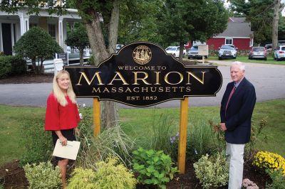 Welcome to Marion
Marion Garden Group member Elizabeth Hatch presents the town’s new sign on September 20 to a large gathering of residents at the Captain Hadley House property at the corner of Front Street and Route 6. The new sign was funded by the Town and is part of the garden group’s Marion beautification project. Photo by Jean Perry
