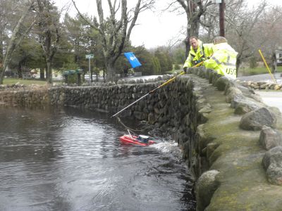 A Lot of Water
Britt Stock and Joan Whitley of the Coast Guard use doppler radar to manually measure the flow of water in the Mattapoisett River after flood waters nocked out the monitoring equipment. Photo by Paul Lopes
